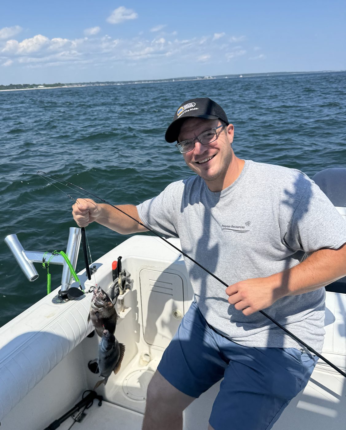 Zach, operations manager at Outdoor Property Services, on the boat with a fish on the line