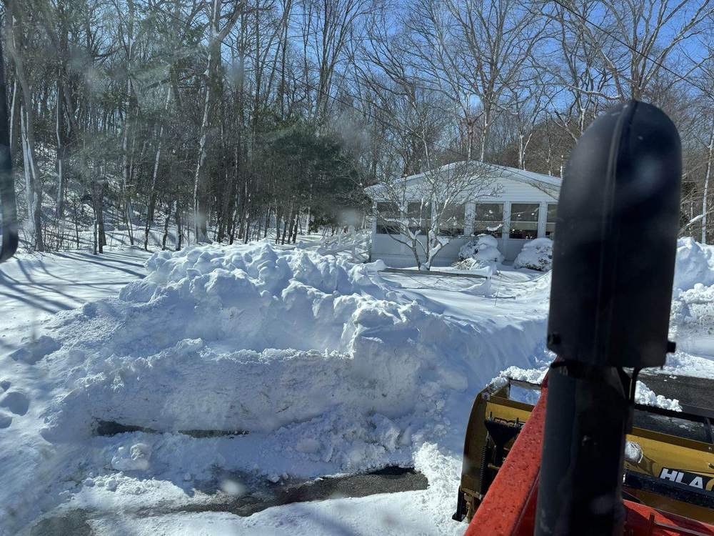 A residential driveway cut clean through deep snow by Outdoor Property Services
