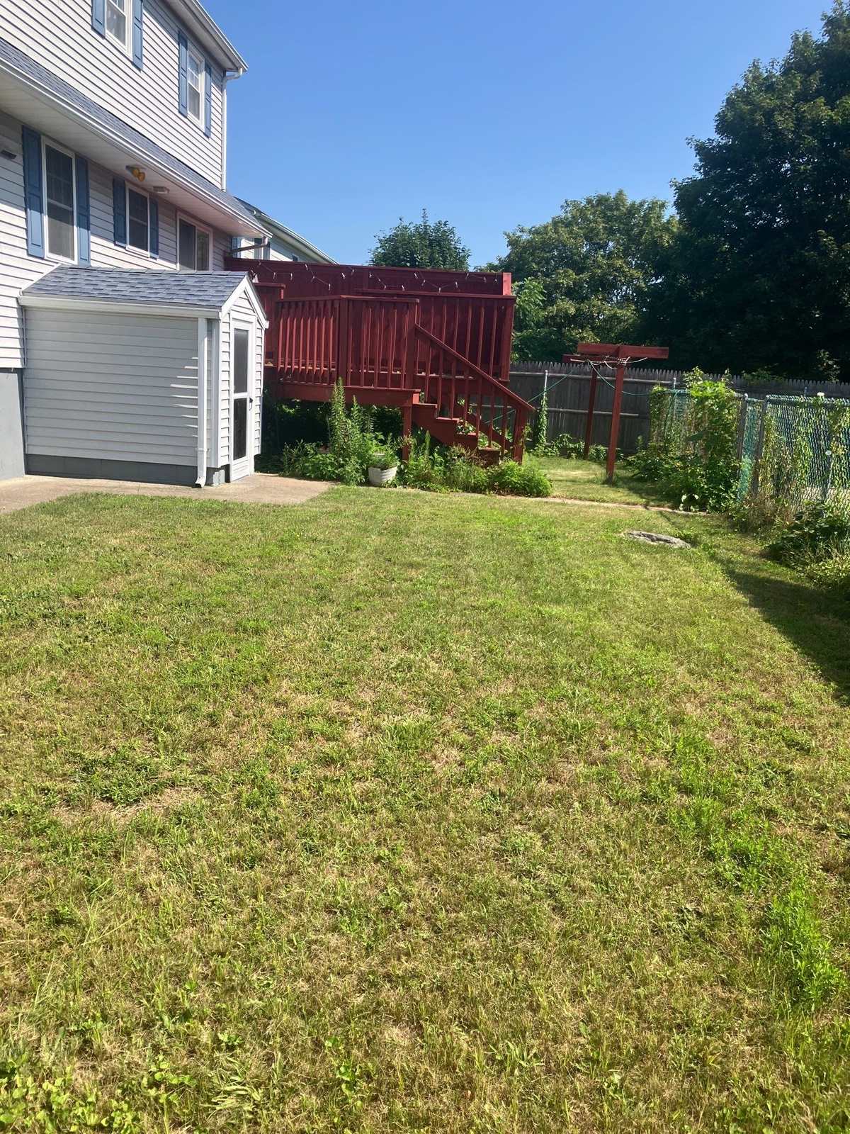 A back lawn cut and trimmed out to the property line on a Westerly, Rhode Island job worked by Outdoor Property Services