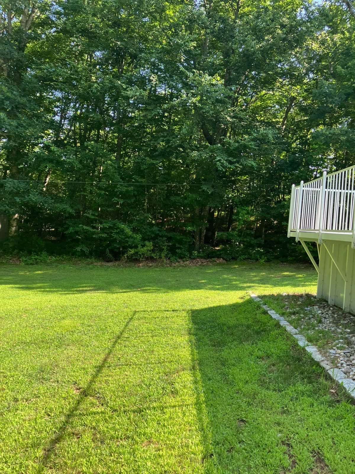 A lawn in Montville, Connecticut, cut and trimmed close along a deck and walk by Outdoor Property Services