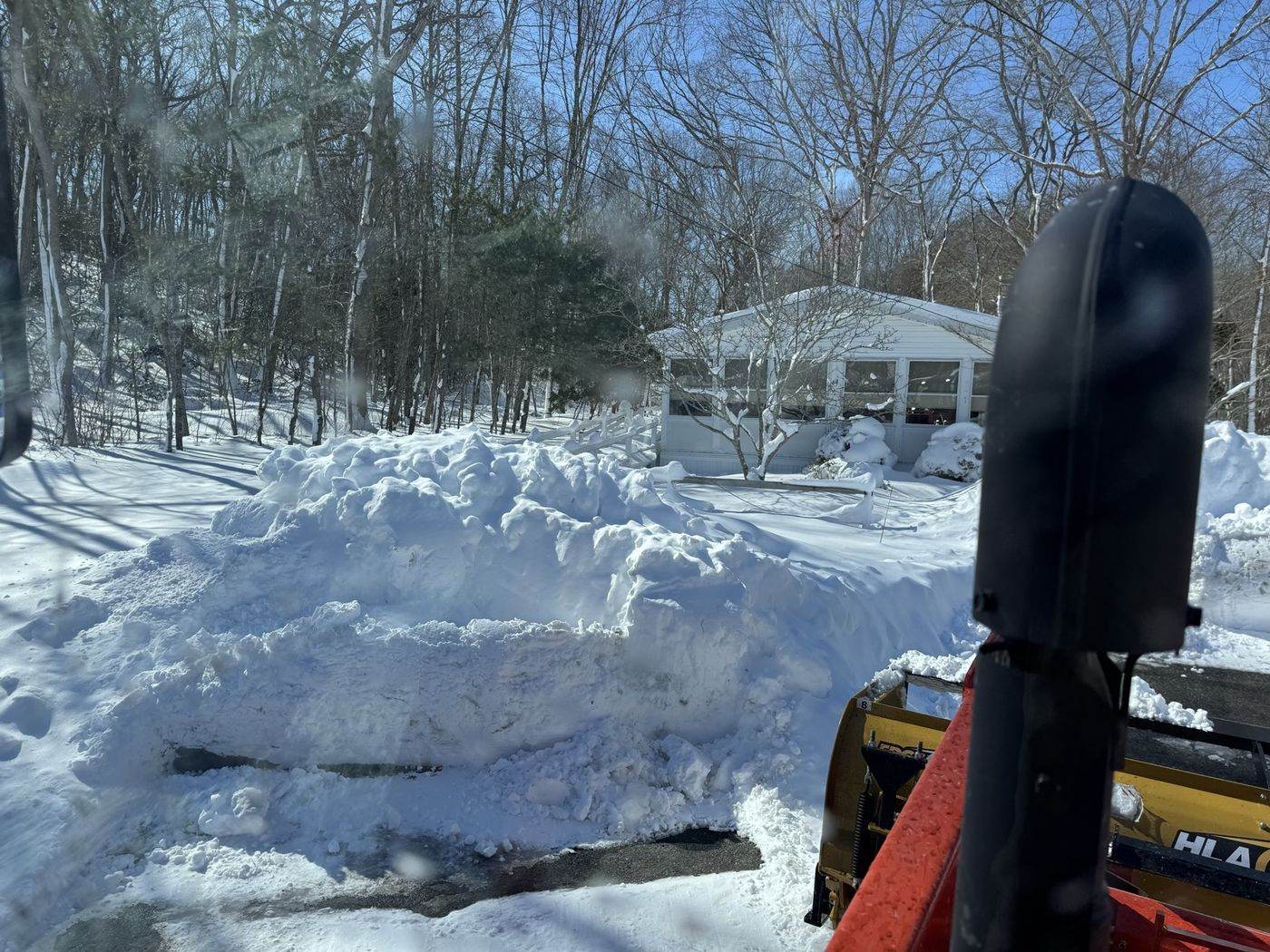 A driveway cut through deep snow with the banks pushed well back