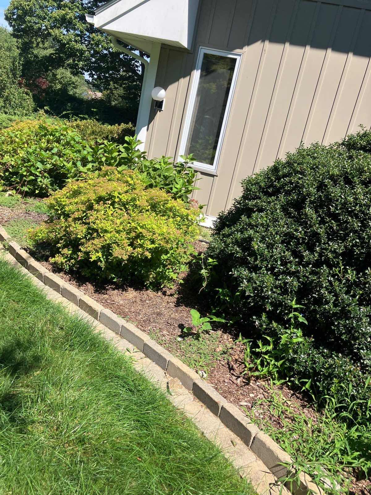 A mulched bed edged the length of a house in Waterford, Connecticut, by Outdoor Property Services